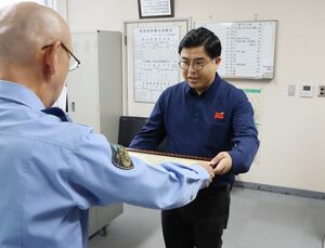新潟県警察秋葉署長から感謝状を受け取るケーズデンキ新津店の南波幸伸さん=新潟市秋葉区新津