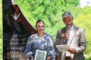 外国人捕虜の追悼式でスピーチする遺族のクイントゥス・ファンデルベイルさん。左は娘のリサさん=10日午前、長崎市