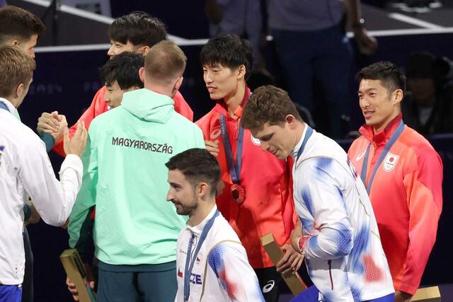 フェンシング男子エペ団体決勝　銀メダルを獲得し、メダルセレモニーで他国の選手と握手する古俣聖（中央）＝８月２日、パリ（新潟日報社写真映像部・新井田悠）