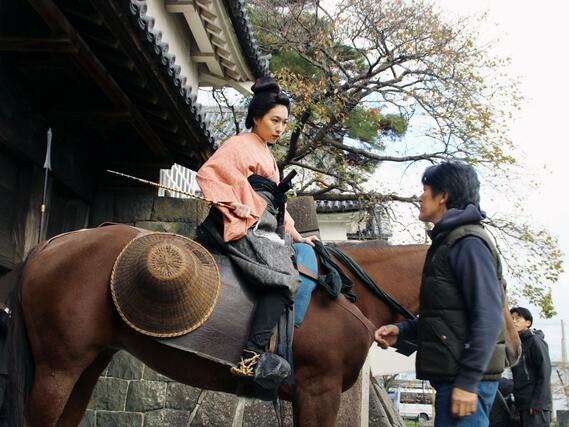 新発田城表門で撮影する木竜麻生さん。地元で行われたロケには家族も見学に訪れた=新発田市