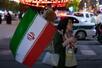 　イラン・テヘランで行われた政府支持者らのデモで、国旗を持つ女性＝４日（ＡＰ＝共同）