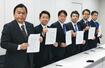 　協議を終え、合意文書を手に写真撮影に応じる与野党６党の税制実務者＝５日午前、国会