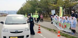 春の全国交通安全運動に合わせ、佐渡署員や園児らが交通安全を呼びかけた=佐渡市両津湊