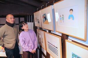会田法行さん(左)と蓮池ももさんの夫妻が出版した絵本「おにがくる」の原画展=柏崎市学校町