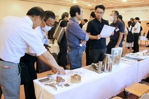 マッチング交流会で、メーカーの展示品を見る参加者ら=燕市白山町3