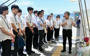 事故現場の歩道橋で、明石市の新人職員に説明する遺族の下村誠治さん(右端)=18日午前、兵庫県明石市