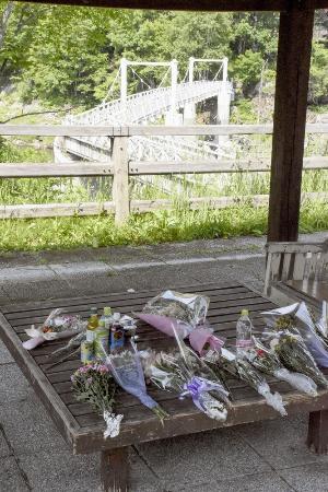 北海道留萌市の女子高生の殺害現場となった、旭川市の神居古潭地区にあるつり橋付近に手向けられた花束=2024年
