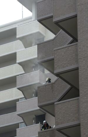 白い煙が上がるマンション=8日、新潟市中央区万代5