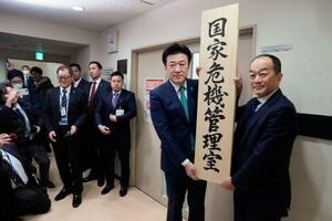 「国家危機管理室」の看板をかける木原官房長官(右から2人目)=20日午前、内閣府