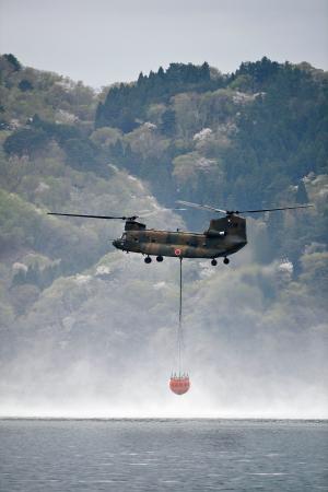 　山林火災の消火活動のため、海水をくみ上げるヘリコプター＝２７日午前、岩手県大槌町