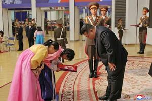 戦死した北朝鮮兵の遺族と面会する金正恩朝鮮労働党総書記(手前右)=29日、平壌(朝鮮中央通信=共同)