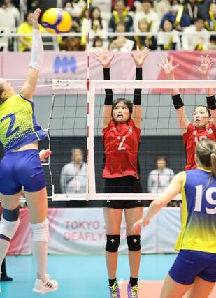 東京デフリンピック準決勝　日本－ウクライナ　ブロックに跳ぶ岡田夕愛（中央）＝２３日、東京都の駒沢体育館