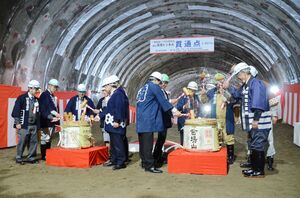 鏡開きを行い、新トンネルの貫通を祝う関係者=津南町赤沢