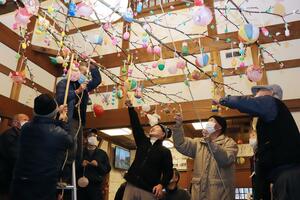 町特産の紙風船や縁起物がつるされた繭玉飾り=1月11日、出雲崎町尼瀬