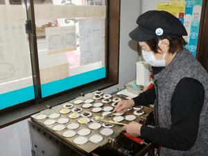 くりくりやの名物の白いおやきを焼く新田田鶴子さん=佐渡市吉岡