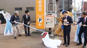 三条一ノ木戸郵便局前に登場した「DIY!!」ラッピング郵便ポストのお披露目式=三条市仲之町