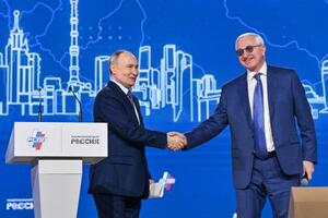 　ロシア産業企業家同盟の年次総会で握手するショーヒン会長（右）とプーチン大統領＝２６日、モスクワ（タス＝共同）