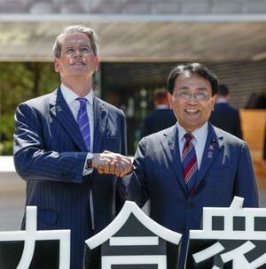 米国館の見学を前にベセント財務長官(左)と握手を交わす赤沢経済再生相=19日午後、大阪市此花区の夢洲