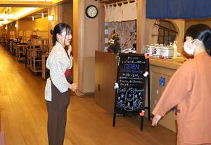 お客さんを出迎える専門学生=湯沢町湯沢