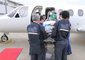 羽田空港に到着した男性患者=7月2日(日本重症患者ジェット機搬送ネットワーク提供、画像の一部を加工しています)