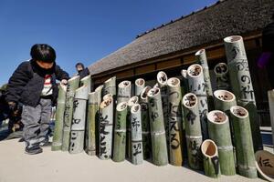 阪神大震災の追悼行事に向け、文字が書き入れられた竹灯籠=10日午前、神戸市北区の「あいな里山公園」