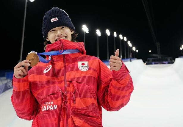 男子ハーフパイプで銅メダルを獲得し、笑顔でポーズをとる山田琉聖＝リビーニョ（共同）