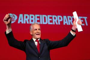 8日、議会選の結果を受け両手を上げるノルウェーのストーレ首相=オスロ(ゲッティ=共同)