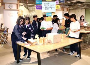 「第三中学校×まちやま 今、中学生が読みたい50のテーマ」で本を展示する作業をする生徒=三条市元町