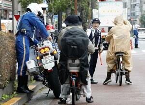 自転車の青切符制度が始まり、東京都内で指導する警察官=4月
