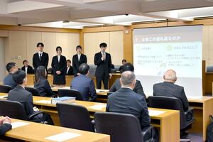 自分たちが開発した新潟市のふるさと納税返礼品について発表する新潟国際情報大学の学生=新潟市役所