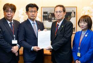 　仁木博文厚労副大臣（中央左）に要望書を手渡す、全国がん患者団体連合会の天野慎介理事長（同右）＝１日午後、厚労省