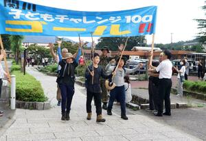 山形県米沢市からの100キロの道のりを踏破し、ゴールで喜びを見せる小中学生=新潟県関川村下関