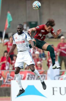 後半、相手と競り合うＤＦゲリア（左）＝４月１２日、高知市のＧＩＫＥＮスタジアム