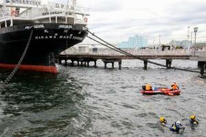 女性とみられる上半身だけの遺体が発見された「氷川丸」付近の海中を捜索する神奈川県警のダイバーら=18日午前、横浜市