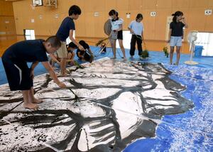 植物などを絵筆代わりにして妙高山を描く児童=上越市長者町