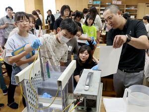 チタン製定規を好みの色合いに仕上げる有田小6年の児童たち=上越市安江