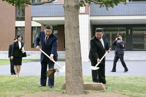 朝鮮労働党の幹部養成機関「中央幹部学校」で植樹する中国の習近平国家主席(手前左)と北朝鮮の金正恩朝鮮労働党総書記=9日、平壌(新華社=共同)