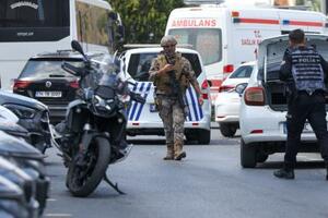 　銃撃事件の現場付近を歩く警察官ら＝７日、トルコ・イスタンブール（ロイター＝共同）