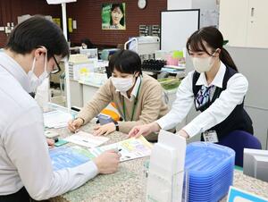 長岡信用金庫本店の窓口で応対する女性職員。2026年度に制服を廃止する=長岡市大手通2