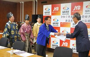 助成金の目録を受け取る若宮八幡宮御神楽保存会の清塚登会長(右から2人目)=南魚沼市役所