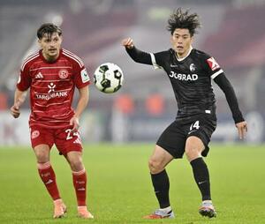 デュッセルドルフ戦で競り合うフライブルクの鈴木唯(右)=デュッセルドルフ(共同)