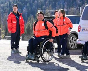 ミラノ・コルティナ冬季パラリンピックの選手村に到着したアルペンスキー男子座位の森井大輝(中央)=28日、イタリア・コルティナダンペッツォ(共同)