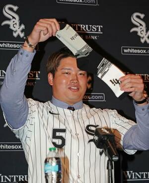 　米大リーグ、ホワイトソックスの入団記者会見で靴下を掲げる村上宗隆内野手＝２２日、シカゴ（共同）