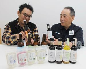 商品化した魚に合うしょうゆなどを前に話すホンマの村岡興治さん(右)ら=新潟市西区山田