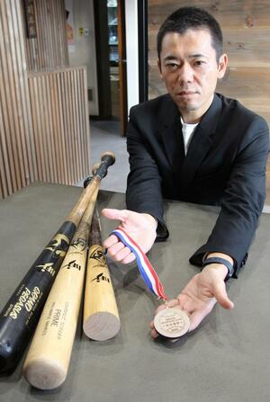 折れたバットを活用したメダルを手にする池田新太郎さん=新潟市東区下木戸3