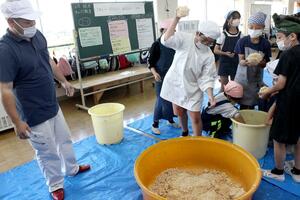 みそ造りを体験する新井中央小の児童=妙高市諏訪町2