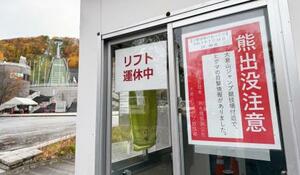 　大倉山ジャンプ競技場（左奥）の近くに掲示された「熊出没注意」のポスター＝２日、札幌市