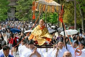 　こしに乗って大仏殿に向かう橋村公英大僧正＝１３日午前、奈良市の東大寺