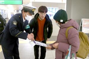 ヘルメットの準備と着用を呼びかける新潟デザイン専門学校の生徒ら＝新潟市中央区花園１