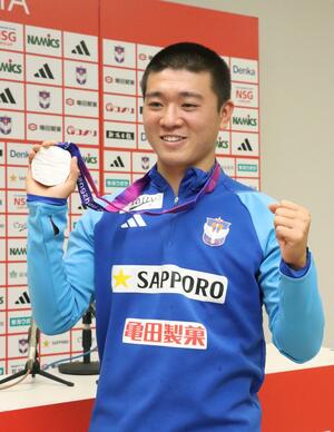 杭州アジア大会の銀メダルを掲げる小見洋太=ビッグスワン